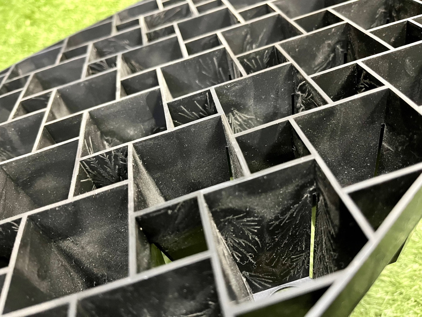 Gros plan en perspective sur la structure des cellules noires du plateau avec système de rainures d air
