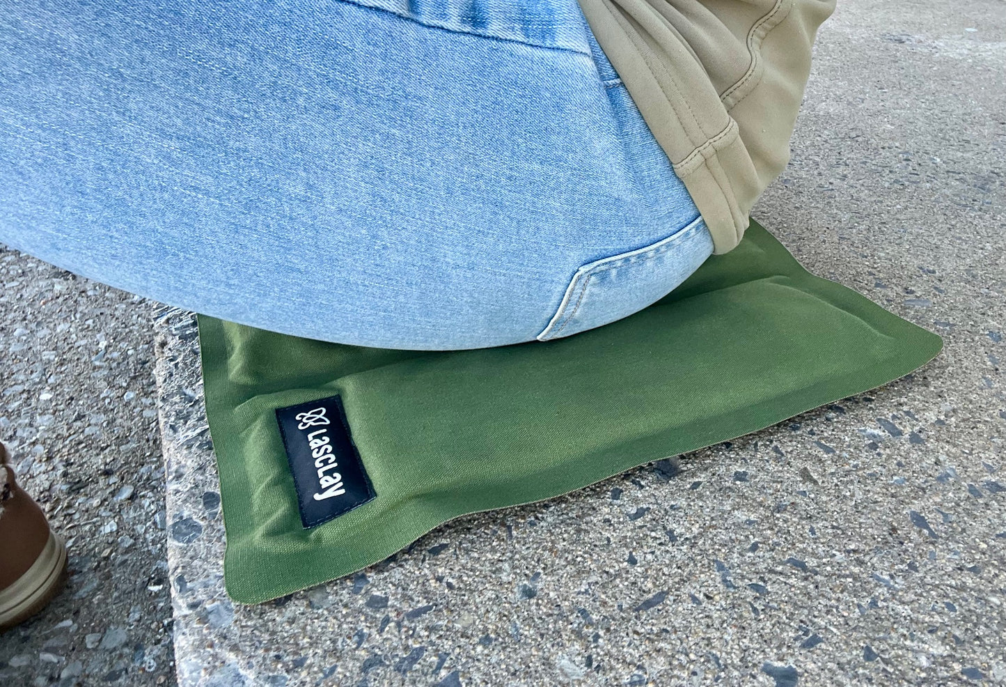 Coussin tapis d'assise isotherme pliable en soie d'asclépiade, présenté déplié, avec une face vert forêt et une face noire.