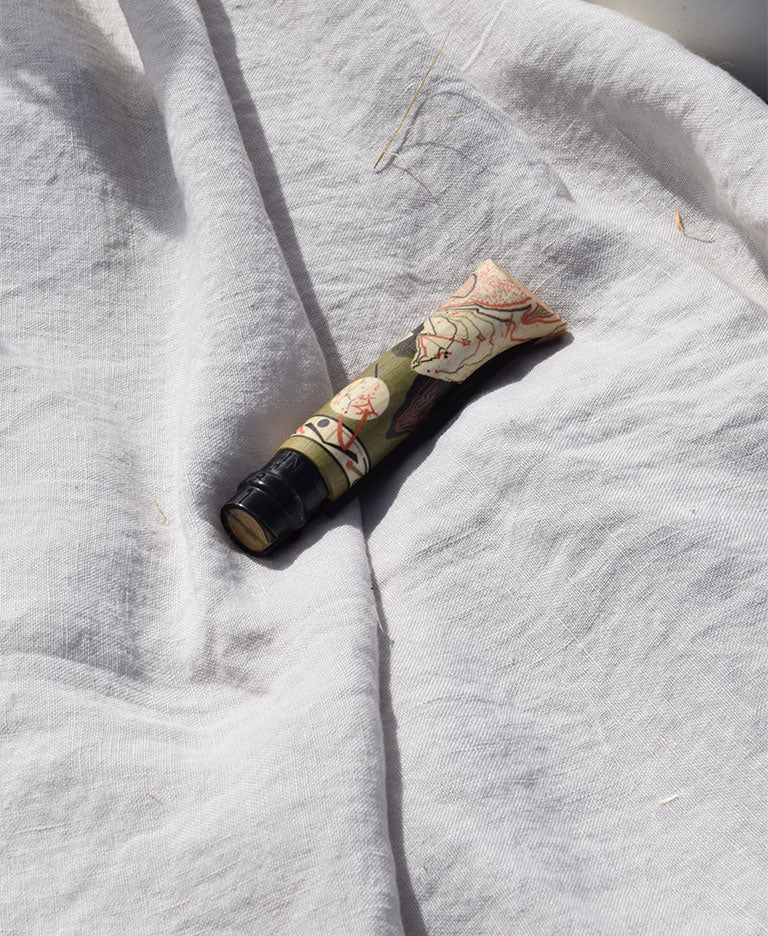 Gros plan sur le manche en bois de charme sublimé d'un couteau Opinel Édition Nature