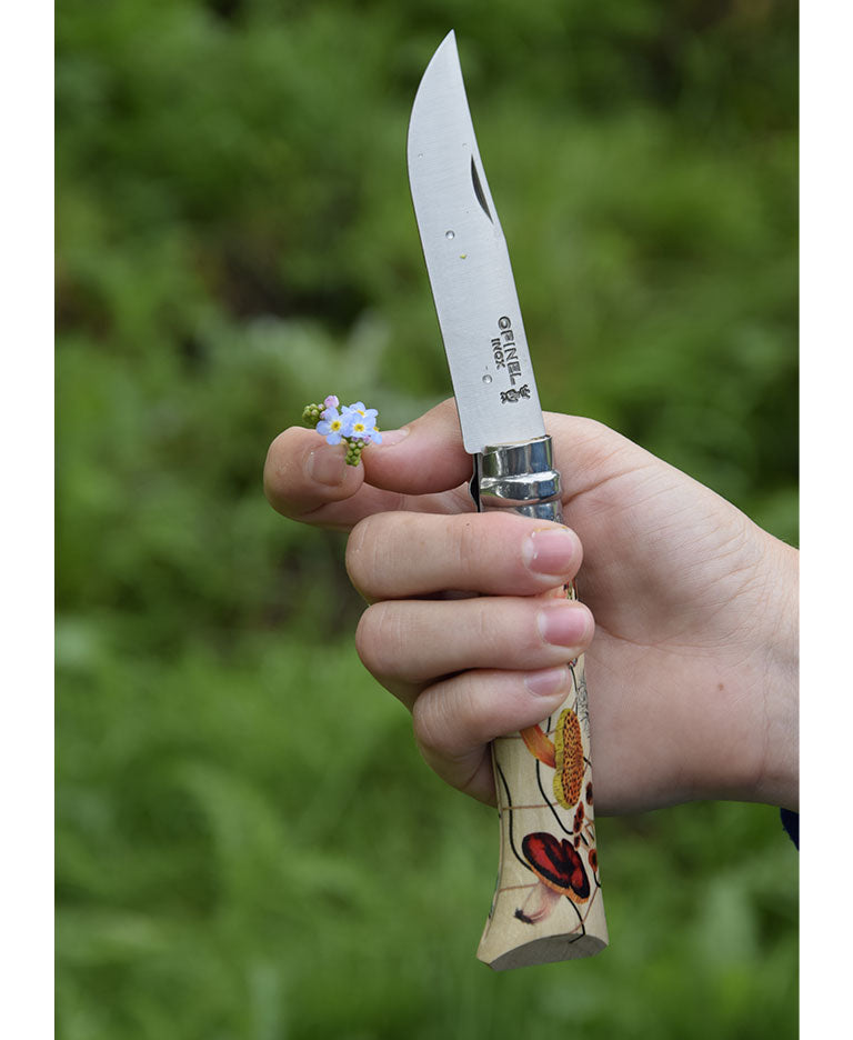 Prise en main d'un couteau Opinel Édition Nature avec lame ouverte en extérieur